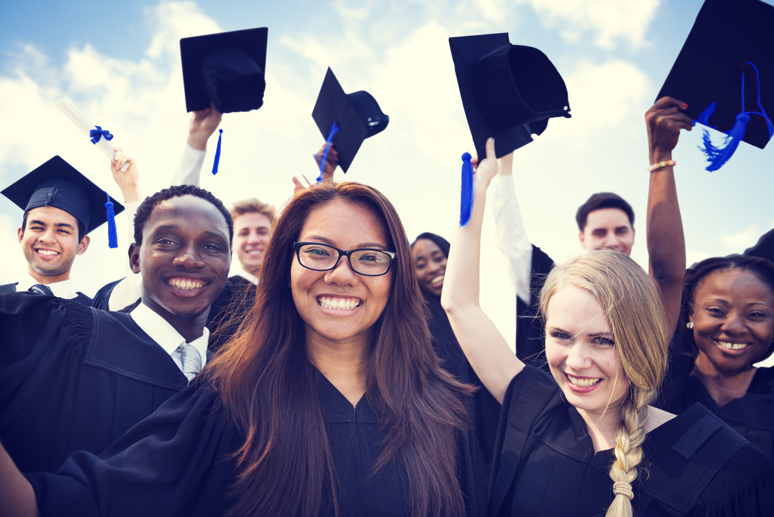 shutterstock_297919265 Newcomer and SLIFE students celebrating their graduation by throwing their hats.